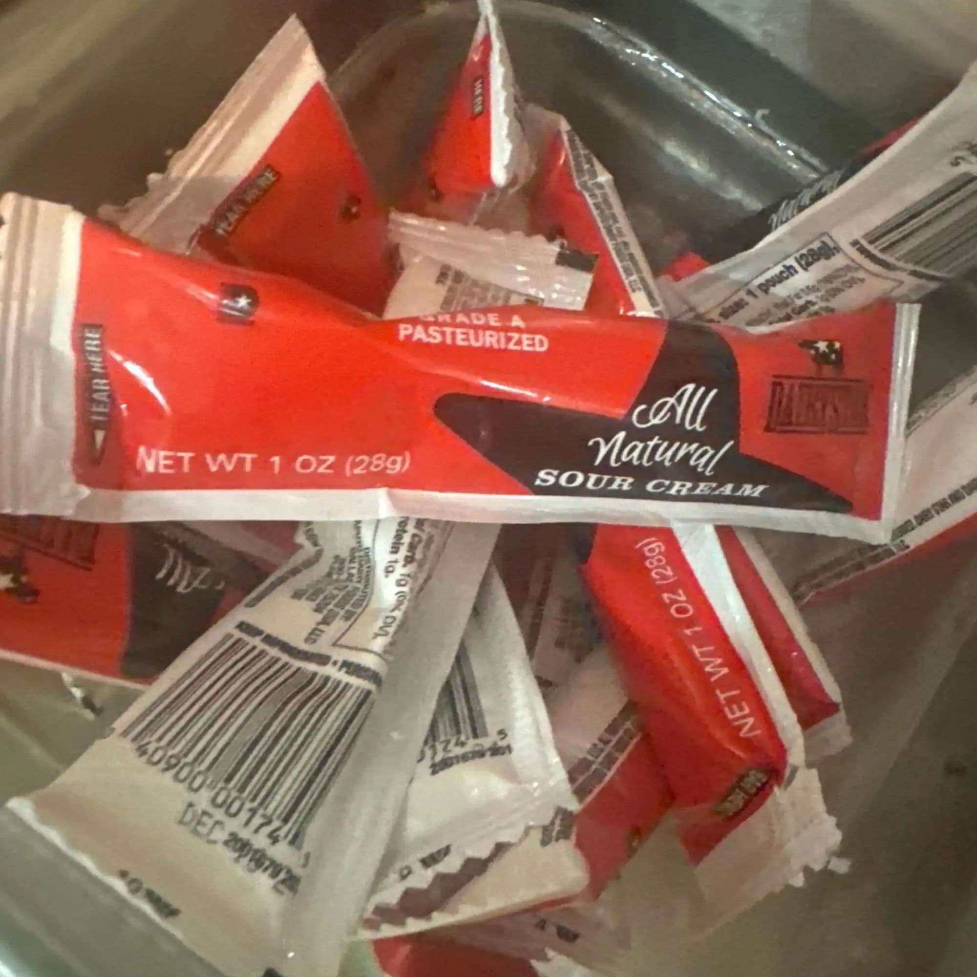 Restaurant food photo before AI enhancement - Isolated a single product from a cluttered collection of jumbled packets. Clean white background with professional lighting showcases the product clearly, making all branding and details visible and appealing.